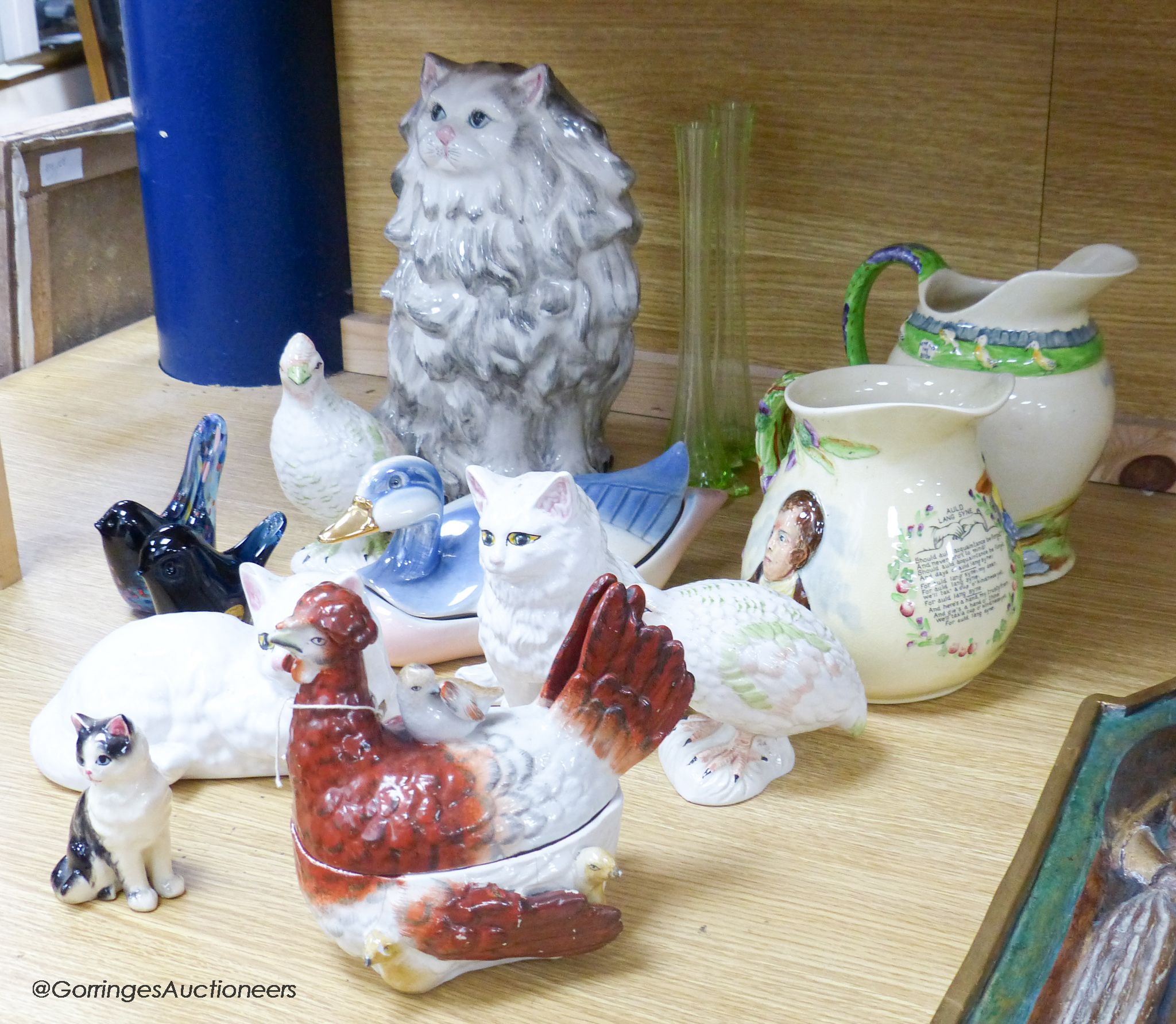 Two Crown Devon musical jugs and various pottery animals including a Staffordshire hen box and two glass 'bird' paperweights, tallest 29cm